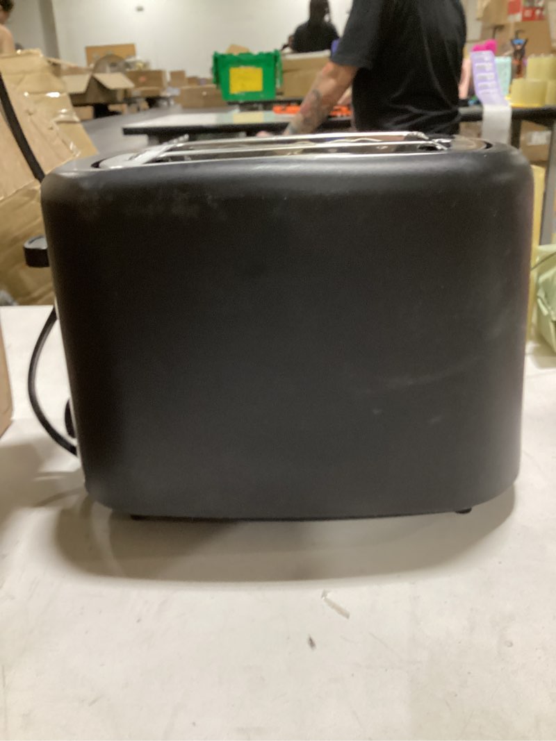 Condition photo showing As Is for amazon basics 2 slice toaster, extra wide slots for bagels, 6 browning settings, removable crumb tray, defrost/cancel/bagel buttons, cord wrap, 900w, black & silver 2 slice silver front