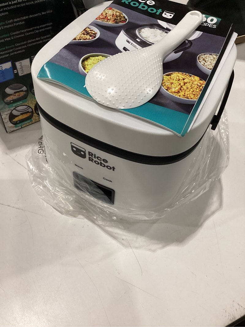 Condition photo showing Good Condition for rice robot personal rice cooker, pfas-free, nonstick. 1 quart capacity, with stainless steel steamer tray, measuring cups, recipe book with 60 recipes, and serving spoon, as seen on tv 2-cup (uncooked) | 4-cup cooked