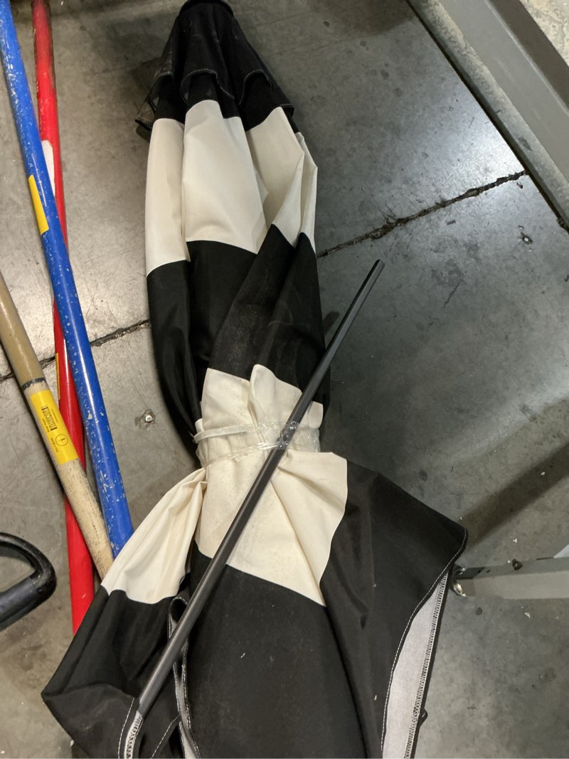 Condition photo showing As Is for better homes & gardens premium 9' b&w market umbrella, fiberglass ribs, crank lift, 3-angle ti