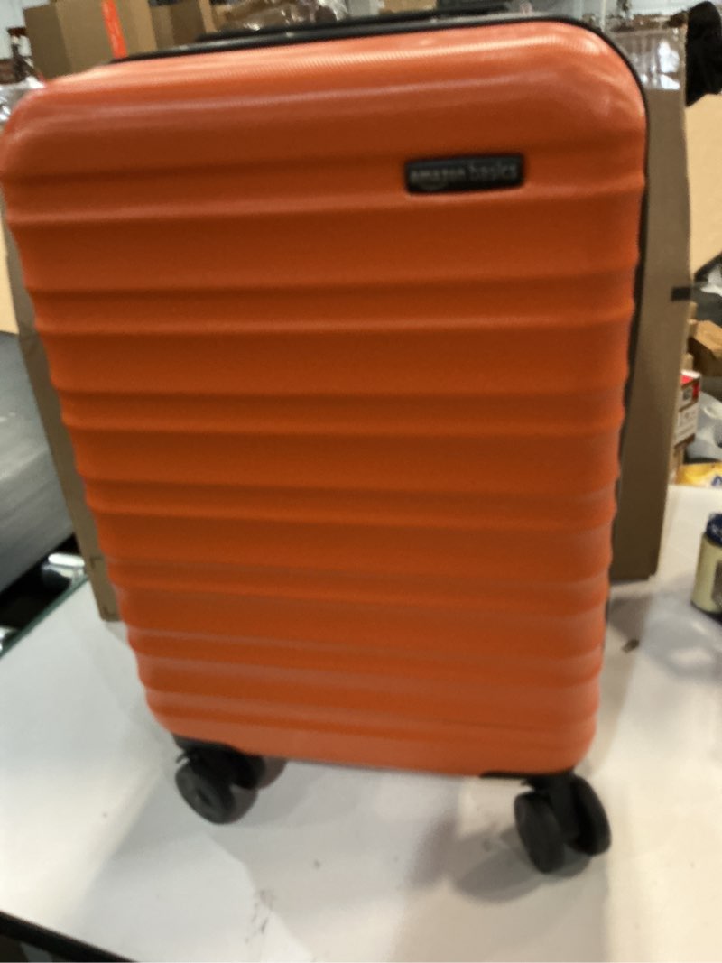 Condition photo showing Good Condition for Amazon Basics 20\" Hardside Medium Checked Luggage, Hardshell Suitcase With Wheels, Expandable For Up to 15% More Space, With Scratch-Resistant Surface, Four Multi-directional Wheels, Orange Orange Medium Checked