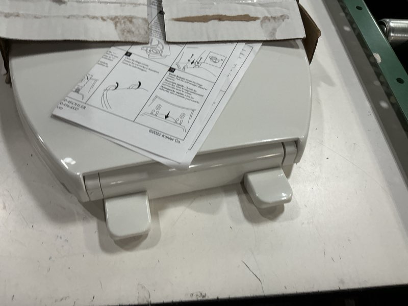 Condition photo showing As Is for kohler 20111-0 brevia, slow close toilet seat, round toilet seat, grip-tight bumpers quick-attach hardware, white