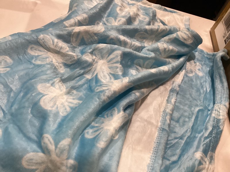 Condition photo showing Good Condition for light blue fleece blanket with white flowers
