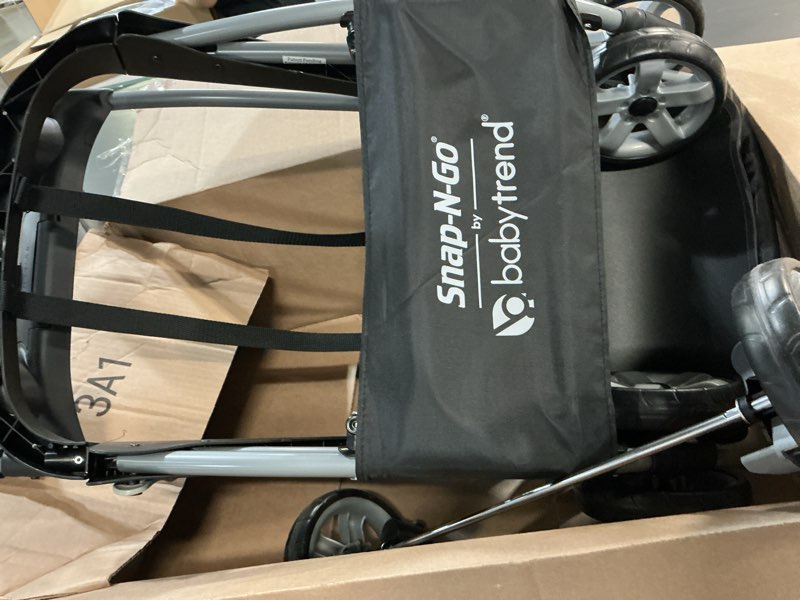 Condition photo showing As Is for baby trend snap n go ex polyester lightweight foldable universal single infant car seat carrier with 2 cup holder and covered compartment, black single stroller