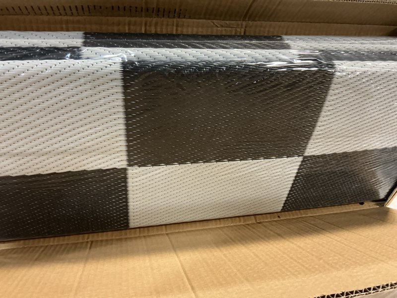 Condition photo showing New/Like New for outdoor 8'x10' geometric waterproof reversible plastic straw rug, black & white check