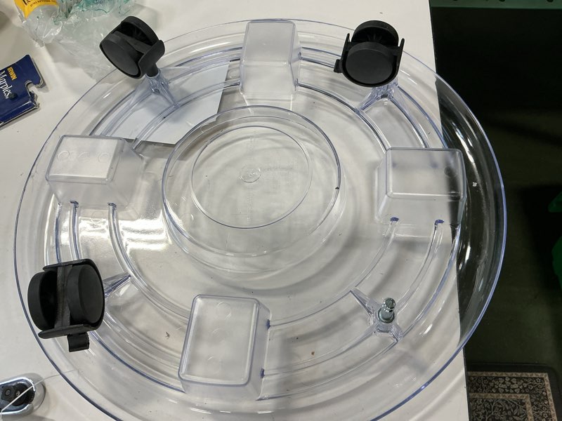 Condition photo showing As Is for (Incomplete) Style Selections 16-in L x 16-in D x 3.34-in H Clear Plant Caddy