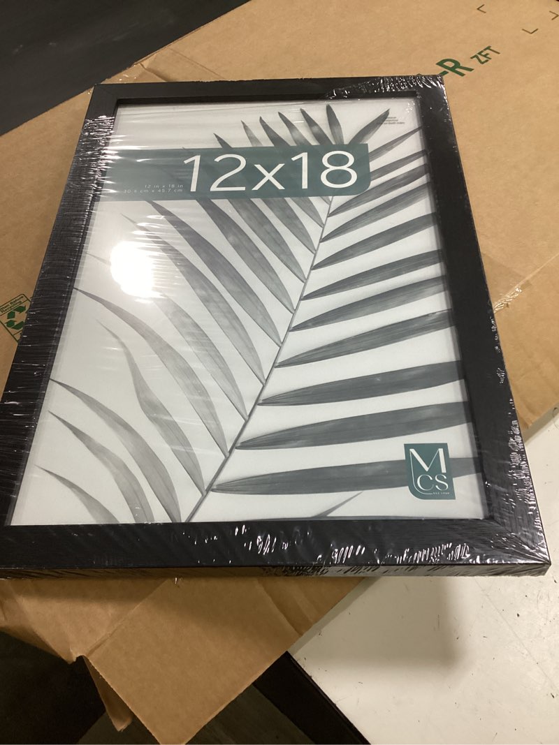 Condition photo showing Good Condition for mcs studio gallery 12x18 picture frame black woodgrain engineered wood, rectangle photo frame for photos, posters & art prints (1-pack) 1-pack black woodgrain 12x18