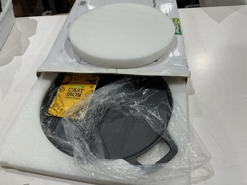 Condition photo showing New/Like New for nutrichef 13-inch flat cast iron pizza pan - versatile pre-seasoned round cooking griddle w/ built-in handles for oven, grill, stove, and campfires