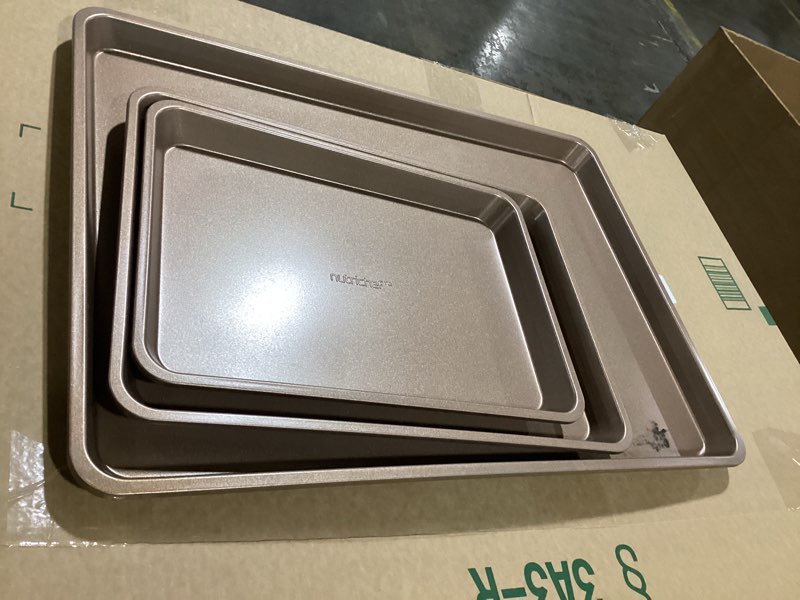 Condition photo showing As Is for NutriChef Nonstick Cookie Sheet Baking Pan - 3pc Metal Oven Baking Tray, Professional Quality Kitchen Cooking Non-Stick Bake Trays - Stylish Metallic Coating, PFOA, PFOS, PTFE Free NC3TRBX3