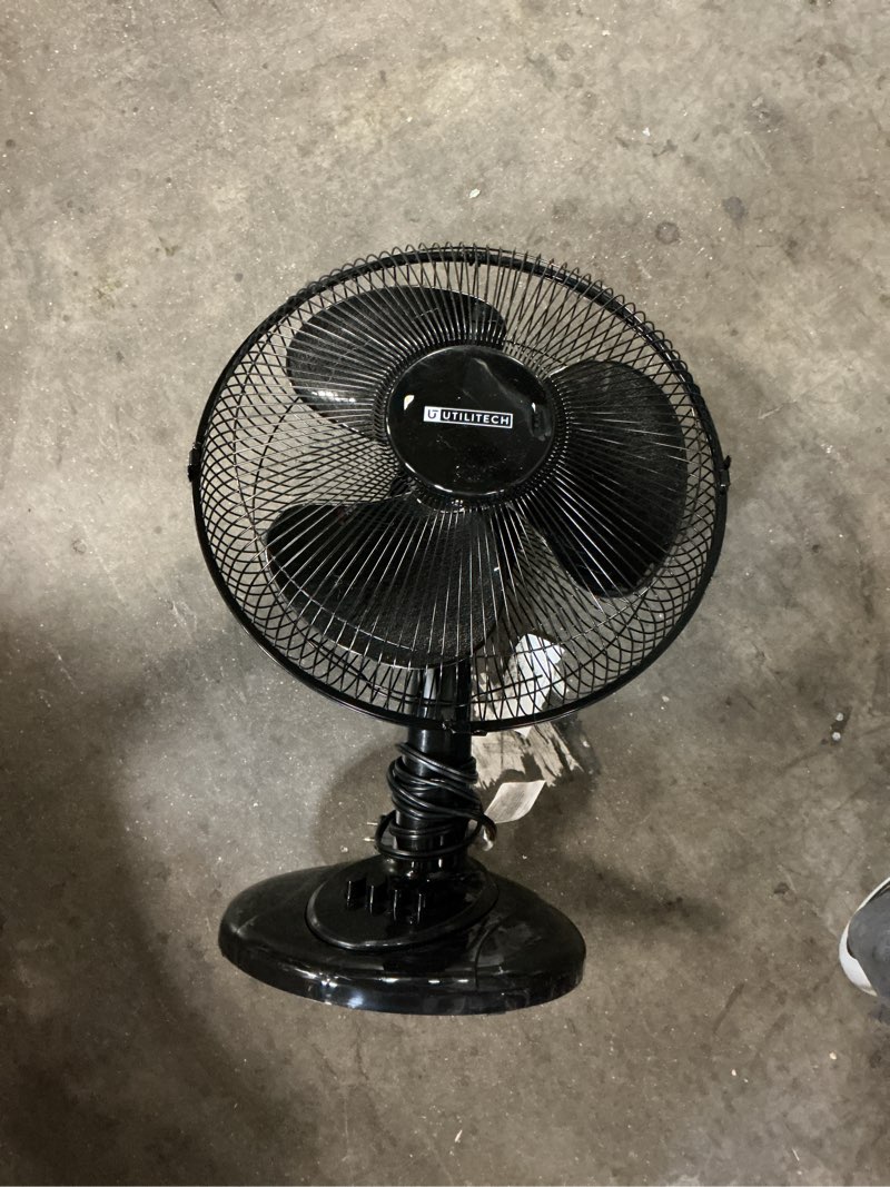 Condition photo showing As Is for  utilitech 12-in indoor oscillating desk fan, in black