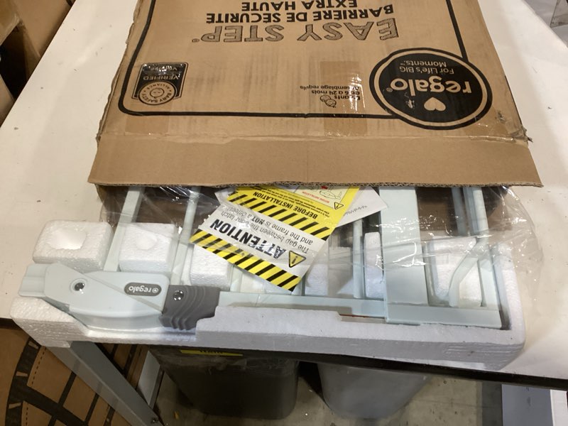 Condition photo showing As Is for regalo safety 36" extra tall baby gate for doorways & bottom of stairs, pressure mounted walk through gate for babies, toddlers & pets, tested & safe for 30 years, american designed, american owned white 29-36.5"w x 36"h