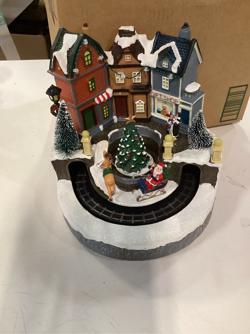 Condition photo showing Good Condition for Christmas Village Houses, Santa Claus with Reindeer and Rotating Tree Lighted Musical Christmas Village with Colorful LED Lights, Battery Operated Collectible Building for Indoor Holiday Table Decor Santa Claus and Reindeer