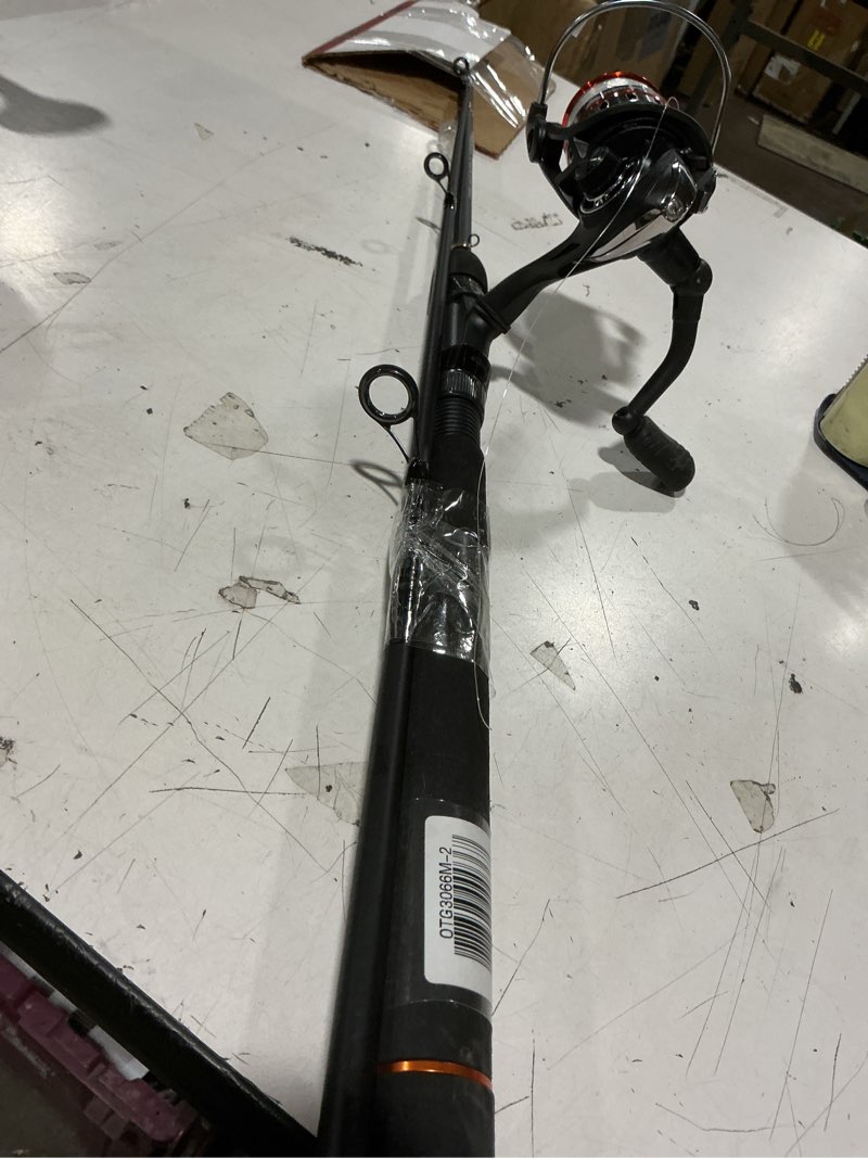Condition photo showing Good Condition for ozark trail grit stick spinning fishing rod and reel combo, 6-foot 6-inch 2-piece medium action rod, size 3000 reel, left & right hand retrieve, black with orange