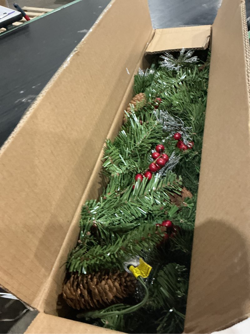 Condition photo showing As Is for national tree company 9 ft pre-lit crestwood spruce artificial christmas garland, christmas decoration with glitter, pinecones, red berries, 50 clear lights, 180 tips, green plug in tree