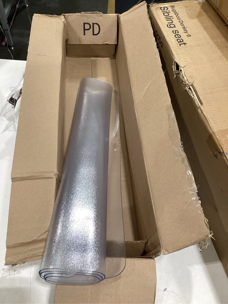 This item is a clear PVC plastic surface protector used for protecting tables or floors.
