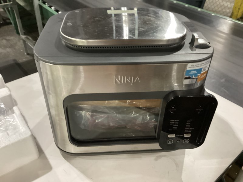 Condition photo showing item condition for ninja combi all-in-one multicooker, oven, & air fryer, complete meals in 15 mins, 14-in-1 functions, combi cooker + air fry, bake, roast, slow cook and more, 3 accessories, stainless steel, sfp701