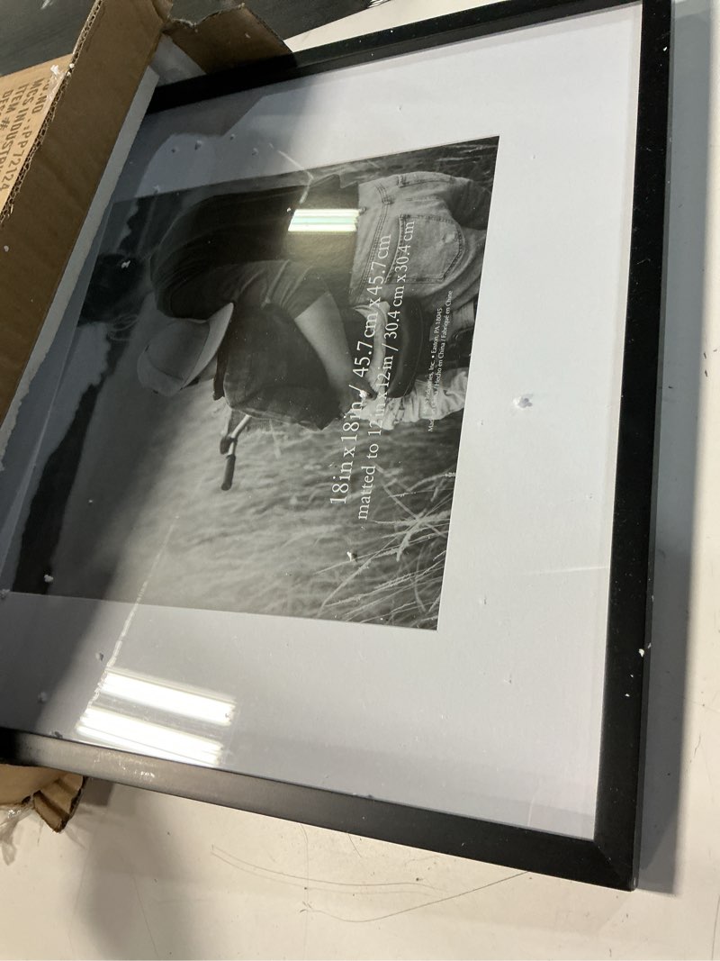 Condition photo showing Good Condition for mcs east village 18x18 matted square picture frame with 12x12 photo display, black wall hanging frame for photos & posters (2-pack) 12x12 2-pack
