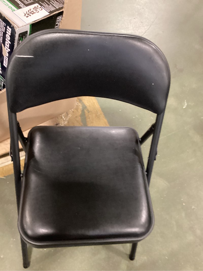 Condition photo showing As Is for National Public Seating 950 Commercialine Black Metal Folding Chair with Black Padded Vinyl Seat - 1/Pack