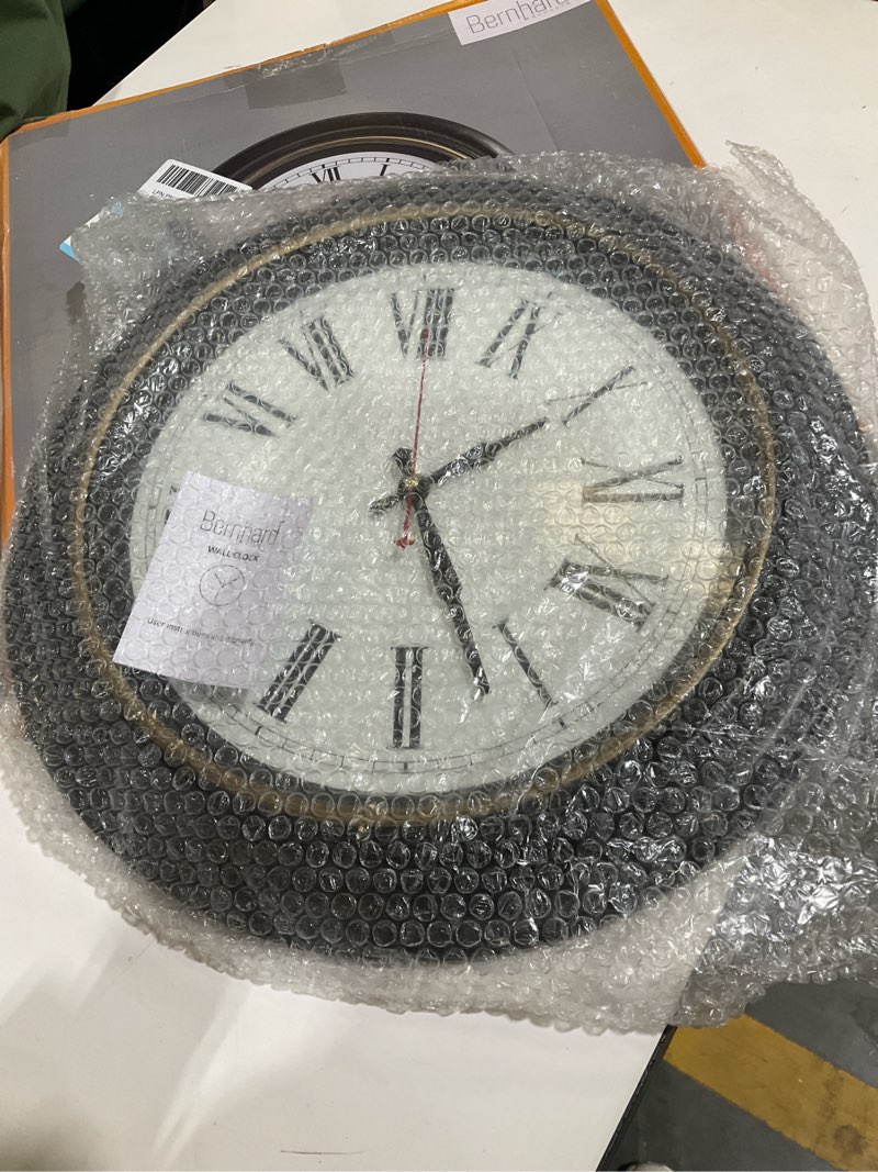 Condition photo showing As Is for bernhard products extra large wall clock, 18 inch, dark brown, quartz silent, battery operated, non-ticking, decorative roman numeral, stylish clock, accurate timekeeping