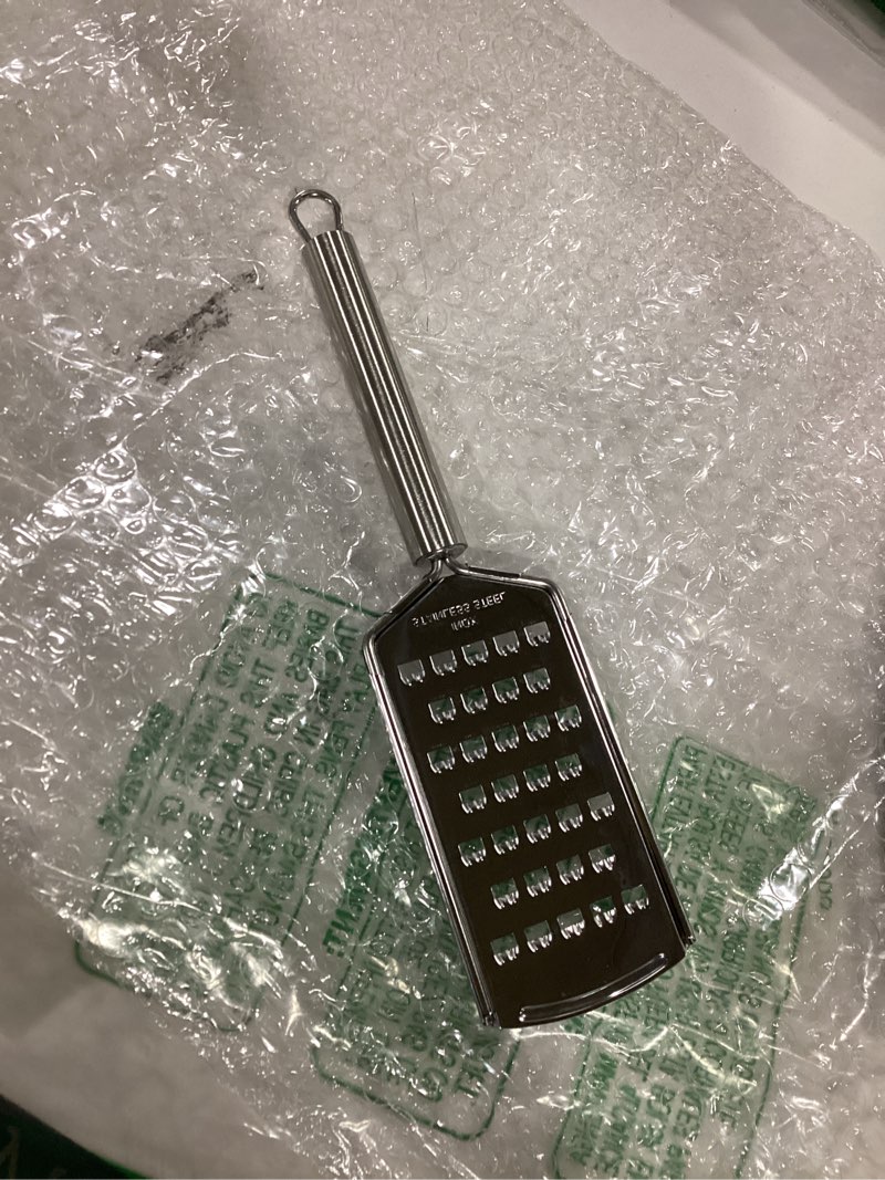 Condition photo showing As Is for Restaurantware Stainless Steel Coarse Cheese Grater - German Standard Lemon Zester with Ergonomic Handle, Sharp Blades, Dishwasher Safe - Handheld Kitchen Grater for Parmesan, Garlic, Ginger 1