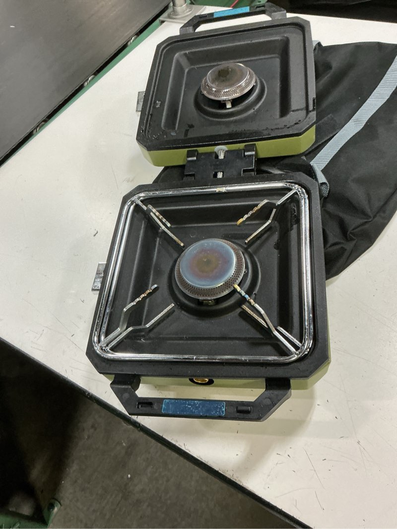 Condition photo showing As Is for odsd 2 burner camping stove with windshield, 20000 btu propane camp stove, portable folding gas stove, camping essentials gear includes frying pan, coffee stand & carry bag, green