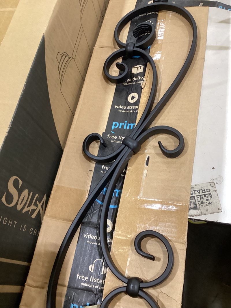 the product is a decorative black wrought iron scroll wall art piece, likely intended for home decor or staircase baluster use. 