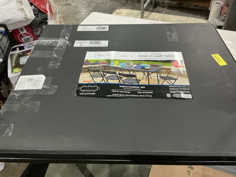 Condition photo showing As Is for mainstays 6 foot bi-fold plastic folding table, black