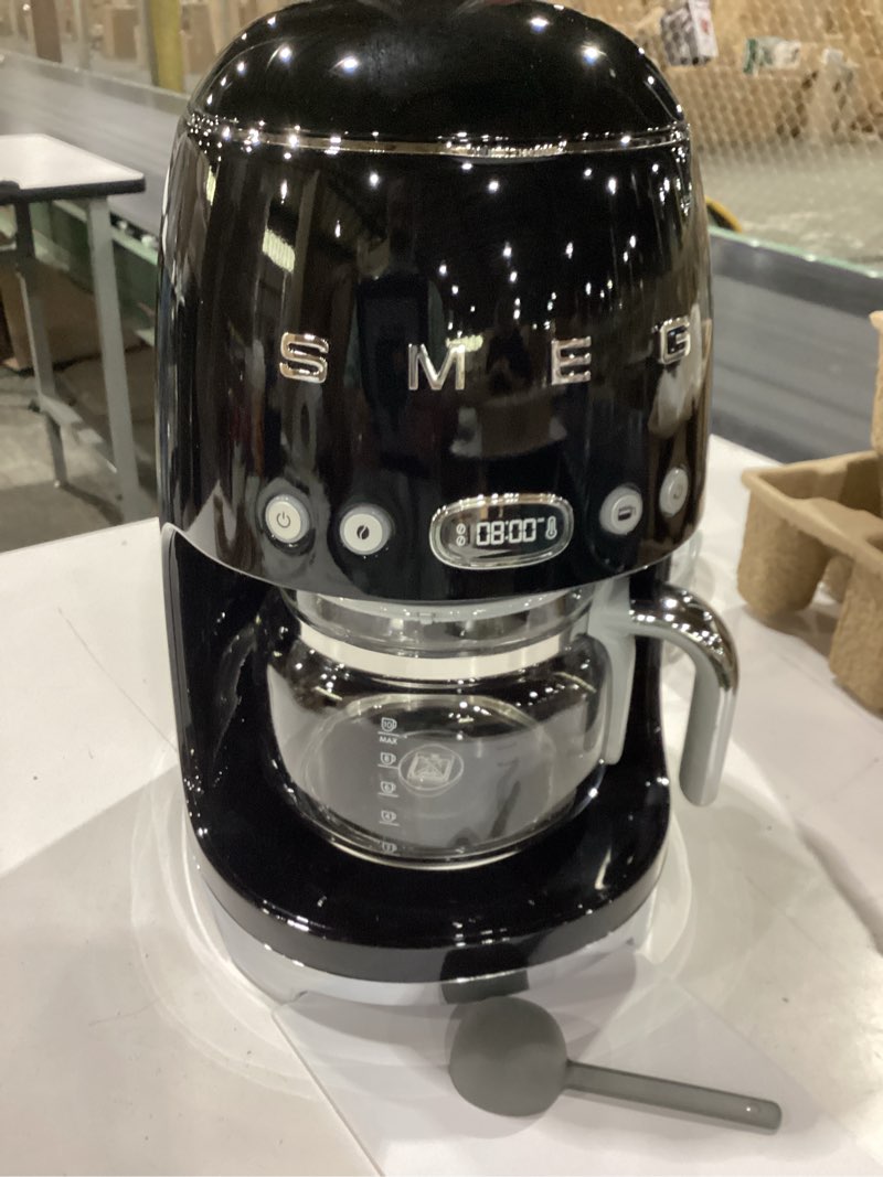 Condition photo showing New/Like New for smeg 50's retro style aesthetic drip coffee machine with 10 cup glass carafe, auto start feature, keep warm plate, and two coffee strength settings (black) 10 cup black