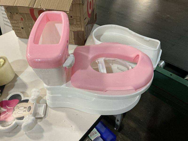 Condition photo showing As Is for bright starts disney junior minnie mouse my size potty training toilet, toddler potty chair with flushing & cheering sounds, removable seat with splash guard & handles, ages 18+ months, up to 50 lbs