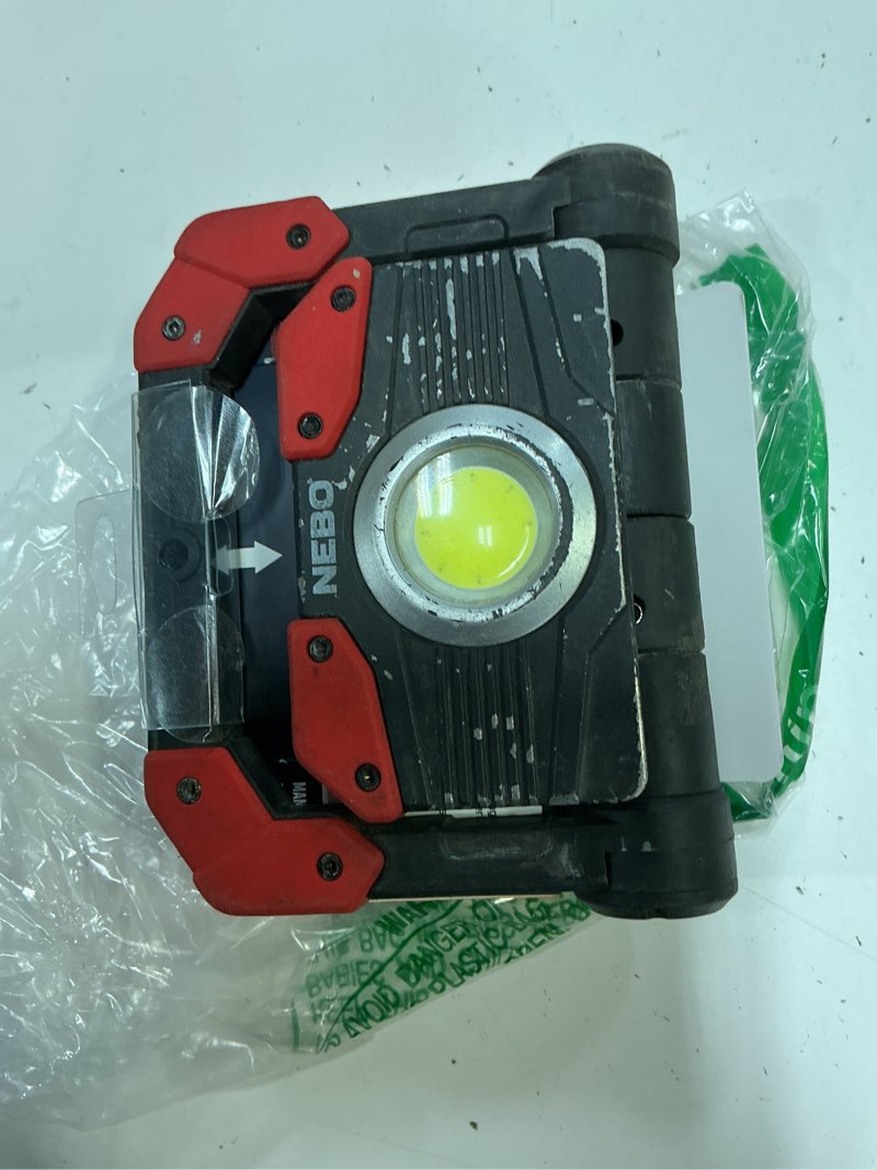 Condition photo showing As Is for nebo omni 2k rechargeable work light | 2000 lumens cob, 6 light modes, rotating magnetic handles, built-in power bank, water resistant, portable camping lantern, includes usb-c charging cable