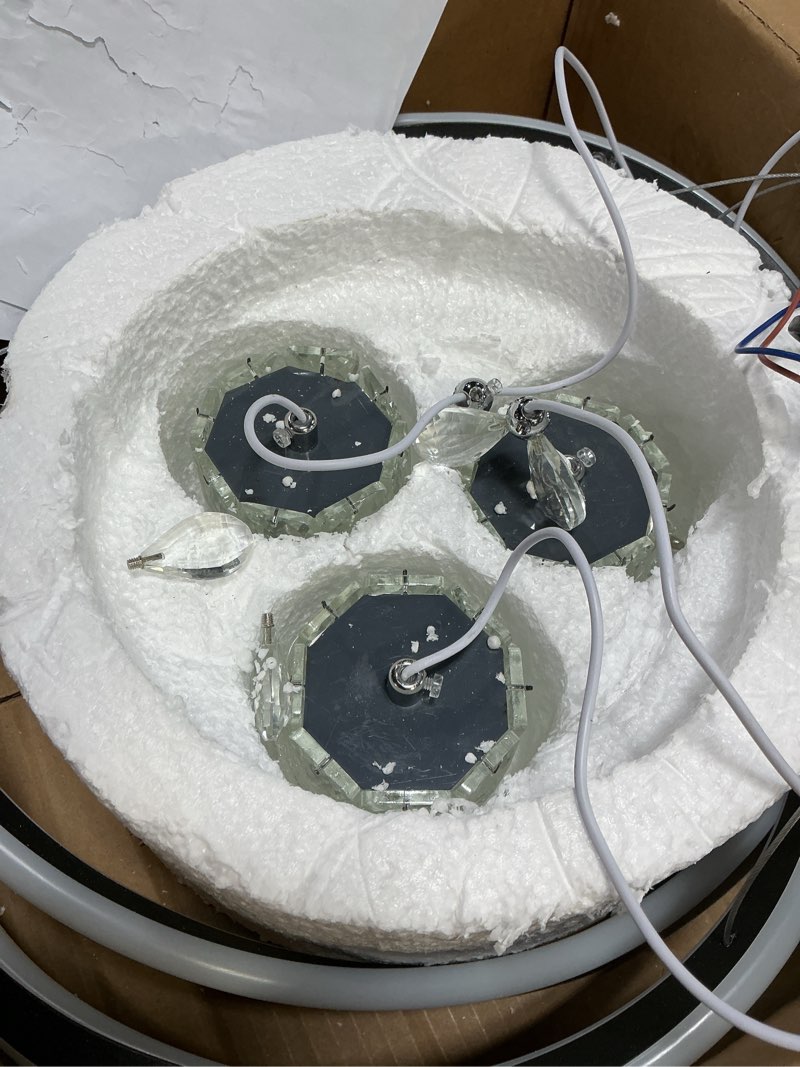 Condition photo showing As Is for This diagram shows a modern multi-tier LED pendant chandelier. It features a combination of interlocking rings and cylindrical light housings suspended from a circular ceiling canopy.