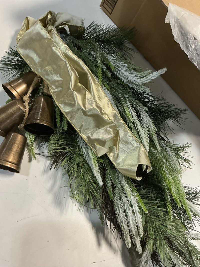 Condition photo showing Good Condition for decorative holiday pine door swag featuring flocked greenery, a gold ribbon, and rustic bells. (Similar to,stock photo)