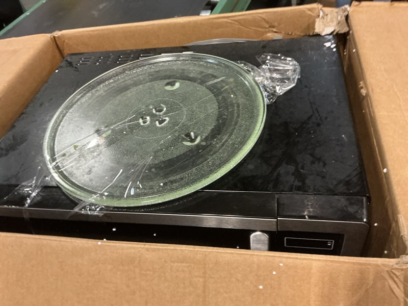 Condition photo showing As Is for farberware 1.1 cu. ft. countertop microwave oven – 1000 watts power, auto cook settings, defrost, easy clean and child safety lock - stainless 1.1 cu. ft. stainless steel