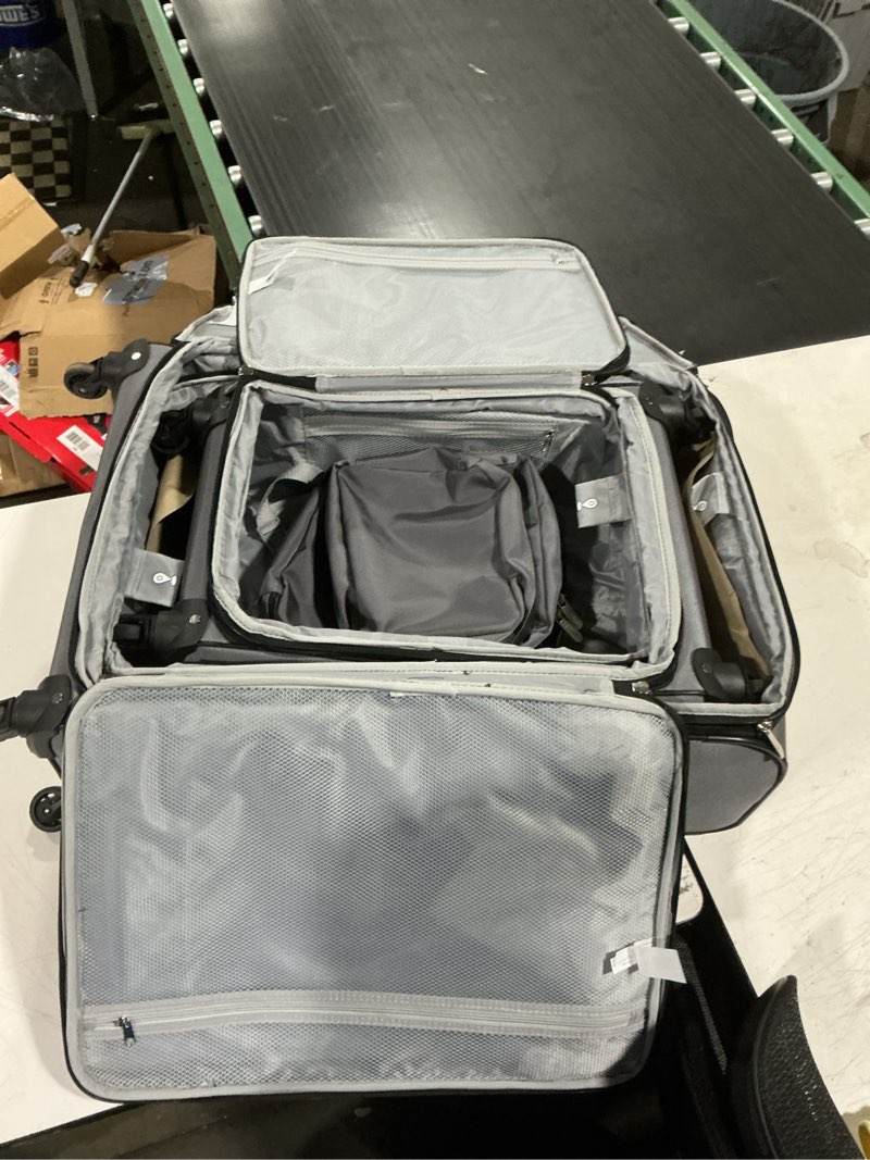 Condition photo showing As Is for protege 7 piece softside polyester luggage set with 360 spinner wheels and divider pockets, includes 28-inch and 24-inch checked bags, 20-inch carry-on bag, 2 medium and 2 large packing cubes, gray