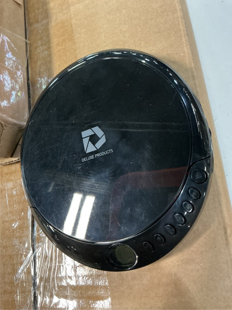 Condition photo showing As Is for deluxe products cd player portable with 60 second anti skip, stereo earbuds, includes aux in cable and ac usb power cable for use at home or in car black_cd
