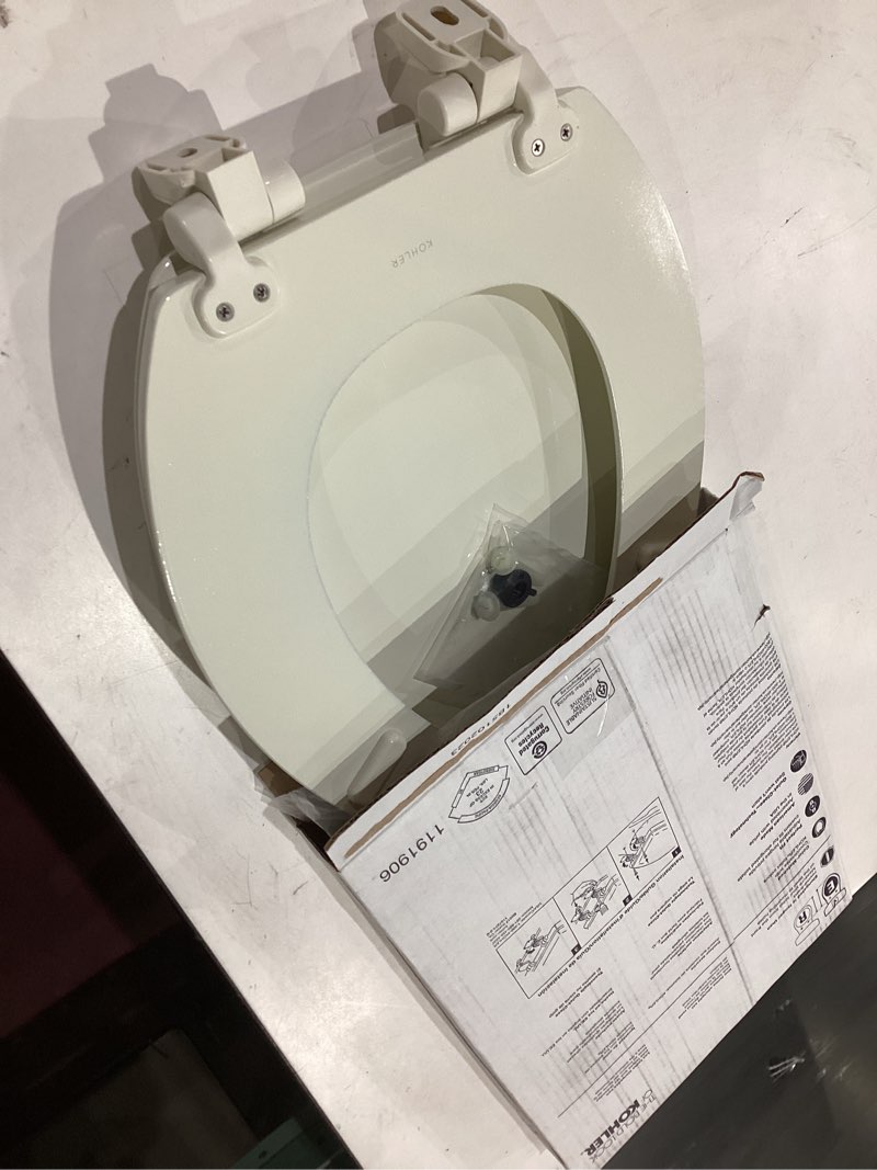 Condition photo showing As Is for kohler stonewood quiet-close, elongated toilet seat soft close, durable wood, easy installation, universal fit, home essentials, biscuit finish, k-20466-96 biscuit elongated double-hinge