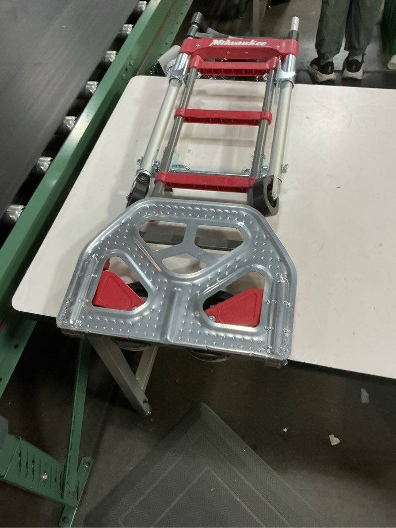 Condition photo showing As Is for milwaukee hand trucks 73333 fold-up convertible hand truck, 4-piece frame, compact storage, 300 lb capacity, red