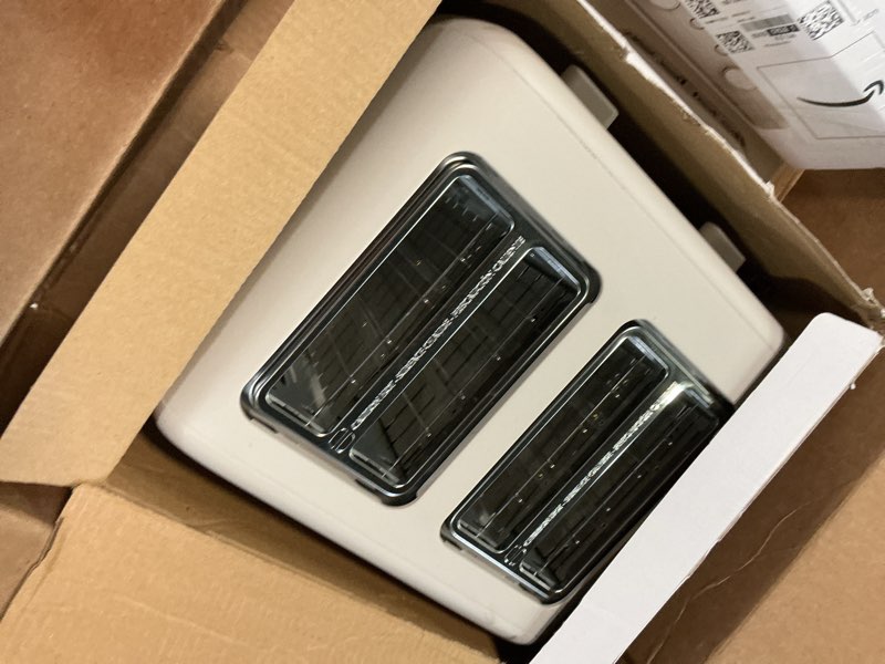 Condition photo showing As Is for bella 4 slice toaster, 6 setting shade control with reheat & cancel buttons, removable crumb tray, anti jam & auto shutoff, 900 watt, oatmilk