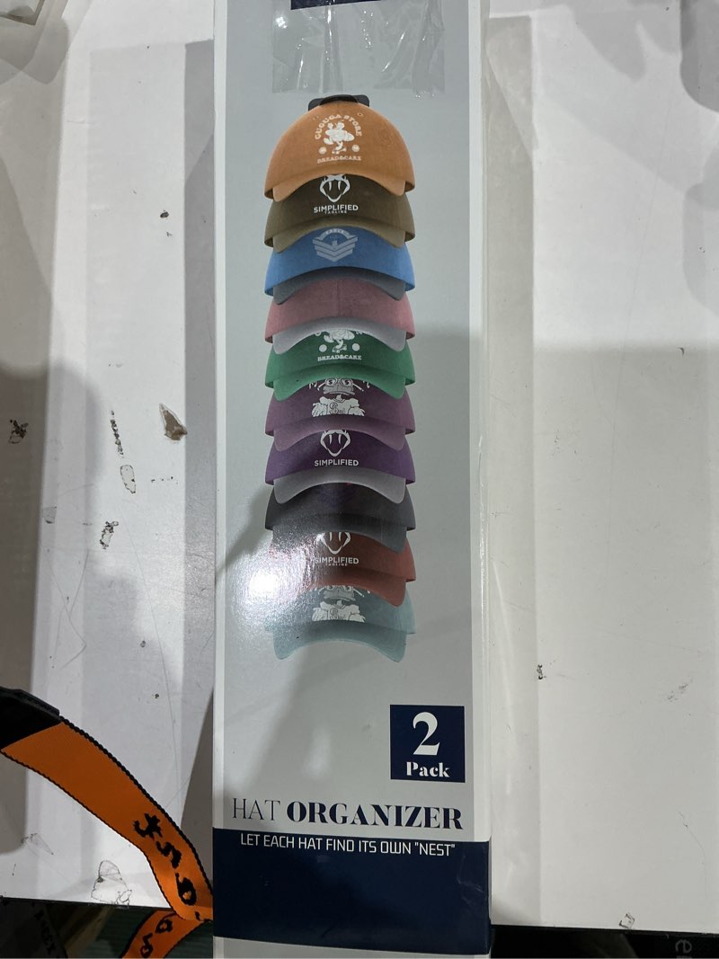 Condition photo showing New/Like New for hat organizer for baseball caps hold up to 40 hats, 2 pack hat rack for wall, strong adhesive hat storage display holder for closet door and wall (black) black 2 pack