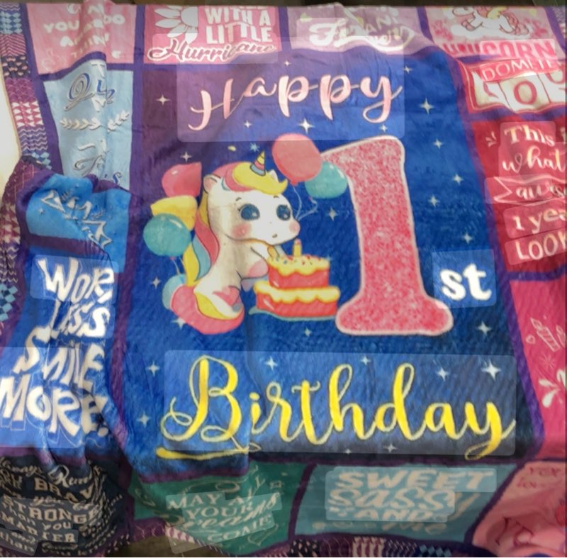blanket designed for a child's first birthday, featuring a unicorn motif and various text messages.