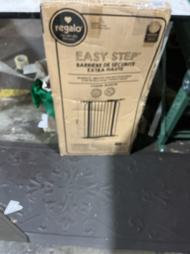 Condition photo showing New/Like New for regalo safety 36" extra tall baby gate for doorways & bottom of stairs, pressure mounted walk through gate for babies, toddlers & pets, tested & safe for 30 years, american designed, american owned white 29-36.5"w x 36"h