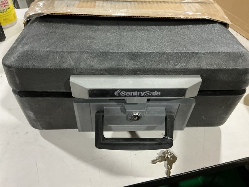 Condition photo showing As Is for sentrysafe fireproof safe box with key lock, chest safe with carrying handle to secure money, jewelry, documents, 0.25 cubic feet, 6.3 x 15.3 x 12.1 inches, 1160 fire resistant box 0.25 cu. ft.