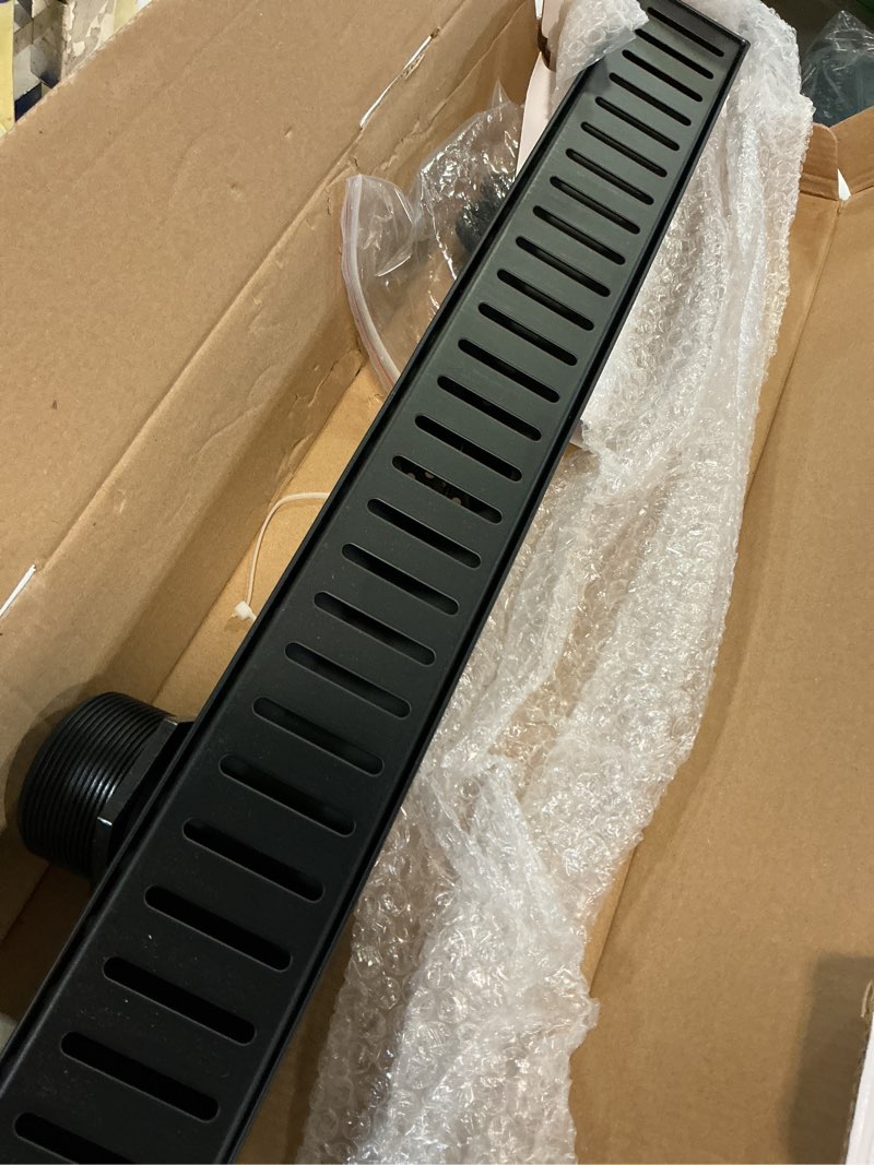 Condition photo showing Good Condition for SaniteModar Linear Shower Drain, 24 inch Matte Black Shower Drain with Removable Capsule Pattern Grate,304 Stainless Steel Shower Drain Include Hair Strainer,Adjustable Leveling Feet