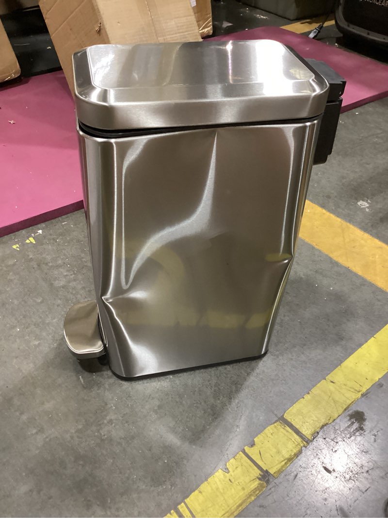 Condition photo showing As Is for home zone living 8 gallon slim kitchen trash can with soft close lid, step pedal, bag tuck band, and removable liner, stainless steel, silver silver solid
