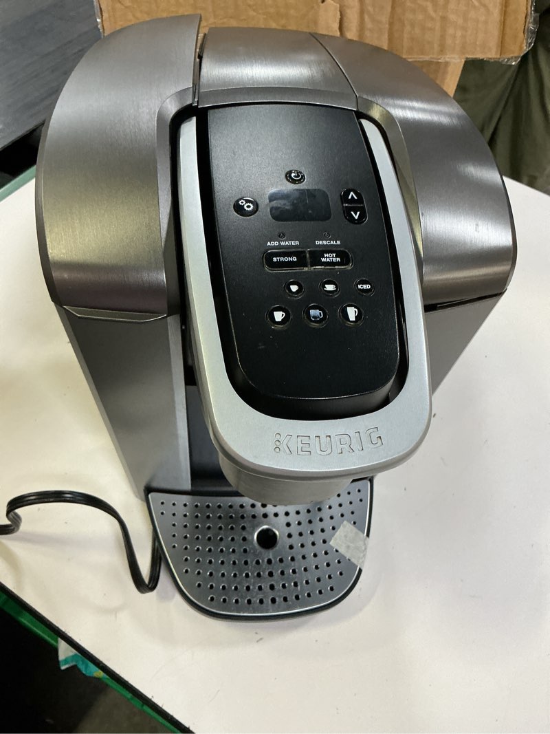 Condition photo showing As Is for (defective , its a broken ) keurig k-elite single serve k-cup pod coffee maker, with strength and temperature control, iced coffee capability, 8 to 12oz brew size, programmable, brushed silver