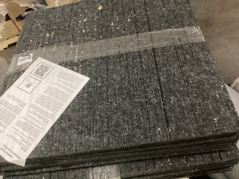 Condition photo showing As Is for mohawk home 24" x 24" indoor/outdoor 0.25" pile height, peel and stick carpet tile, black polyester, (15 tiles) (60 sqft/box)