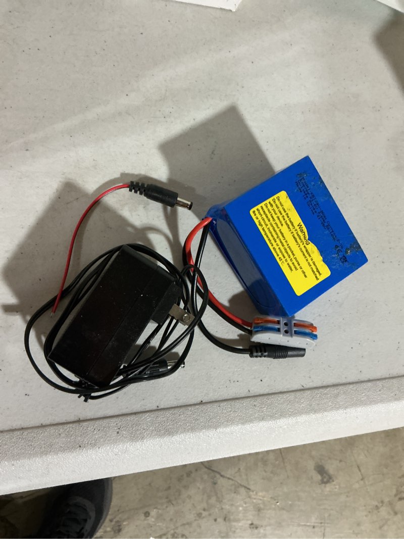 Condition photo showing As Is for kbt 24v 2.6ah rechargeable lithium replacement battery with charger, charging cable, cable connector