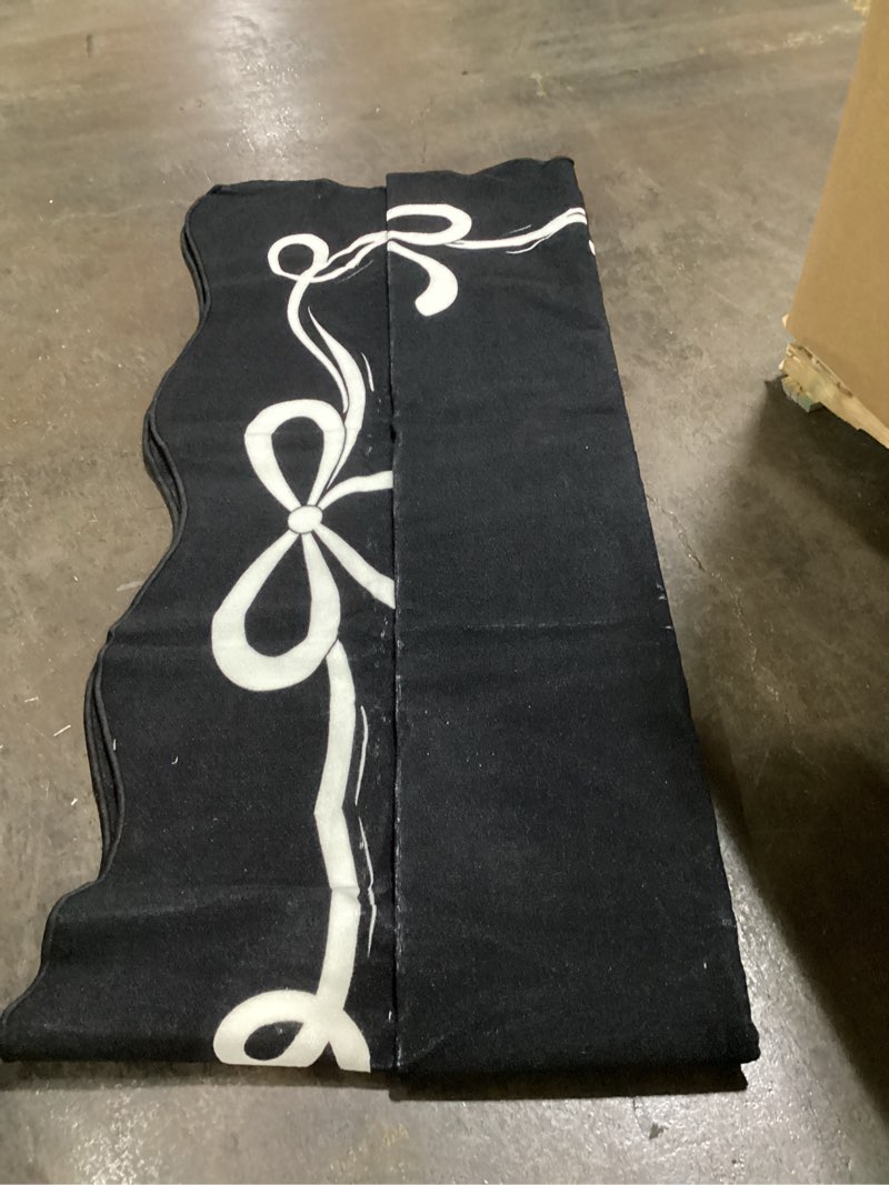 Condition photo showing As Is for 4’ x 11’ black with white bows scalloped edge area rug