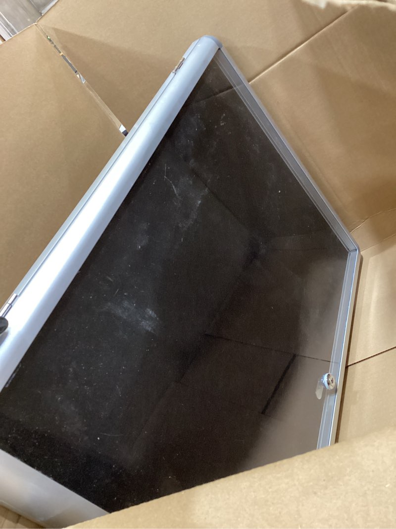 Condition photo showing As Is for Mifuro 26"x20" Enclosed Bulletin Board, Lockable Weather-Resistant Aluminum Cork Noticeboard for School & Office, Silver Frame w/Black Flet Silver Frame W/ Black Flet 26” x 20”