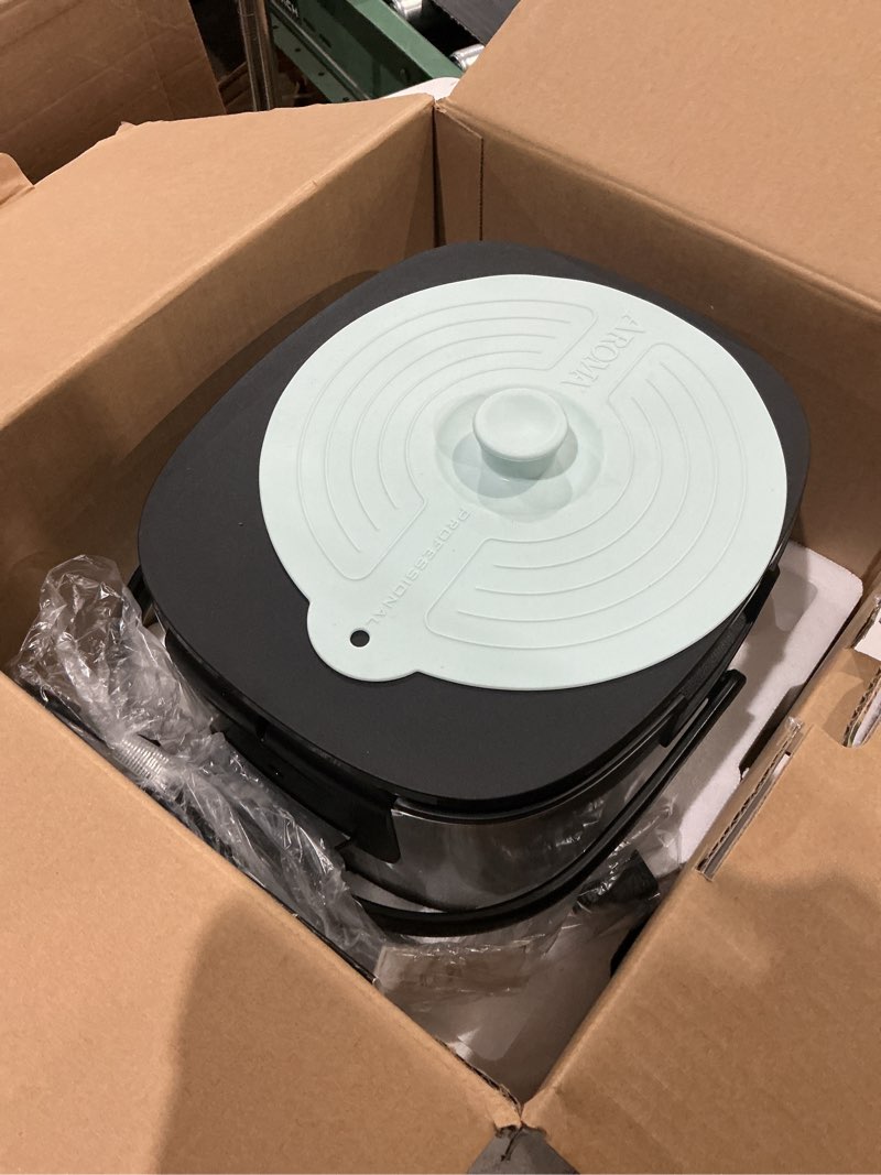Condition photo showing As Is for aroma® 6-cup (uncooked)/ 12-cup (cooked) slow cook rice cooker and brown rice cooker with lift-out pot handles and silicone storage lid, pfas-free ceramic coating professional corecoat ceramic