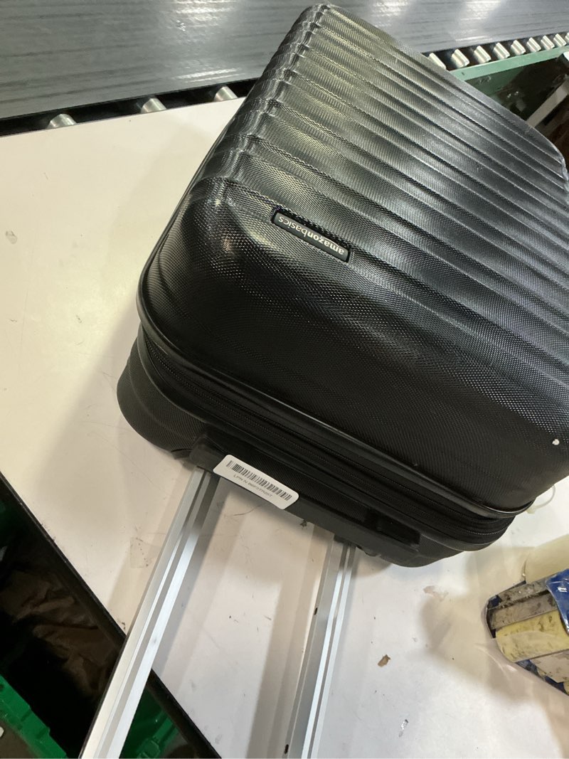 Condition photo showing As Is for amazon basics 21" hardside carry-on luggage, hardshell suitcase with wheels, expandable for up to 25% more space, with scratch-resistant surface, four multi-directional wheels, black black carry-on